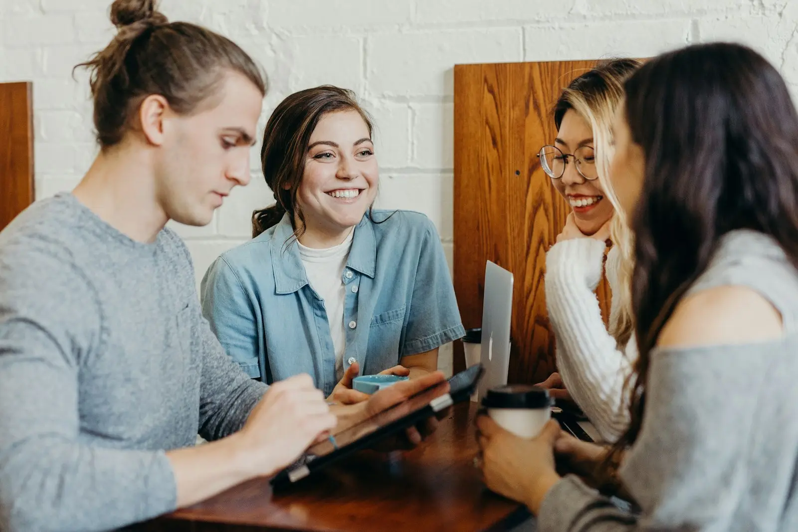 Drie collega's in overleg rond een laptop
