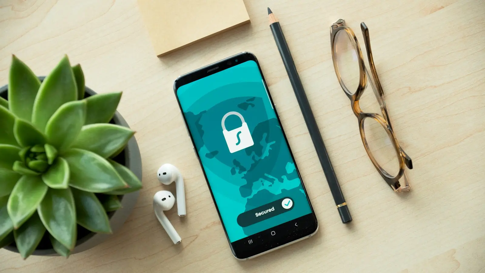 Smartphone met een slotje op het scherm naast een plant