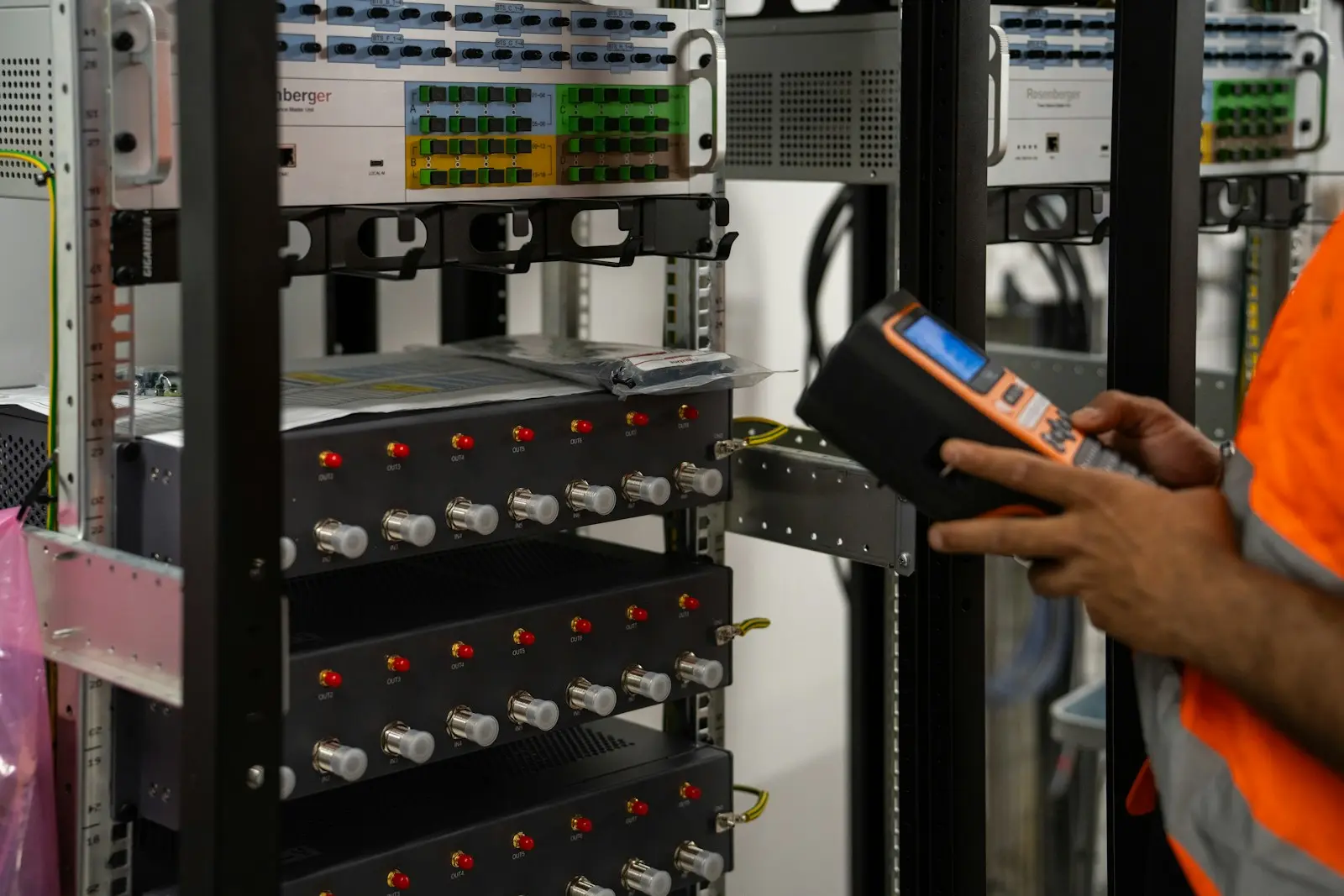 Technicus controleert een serverrack met een meettoestel