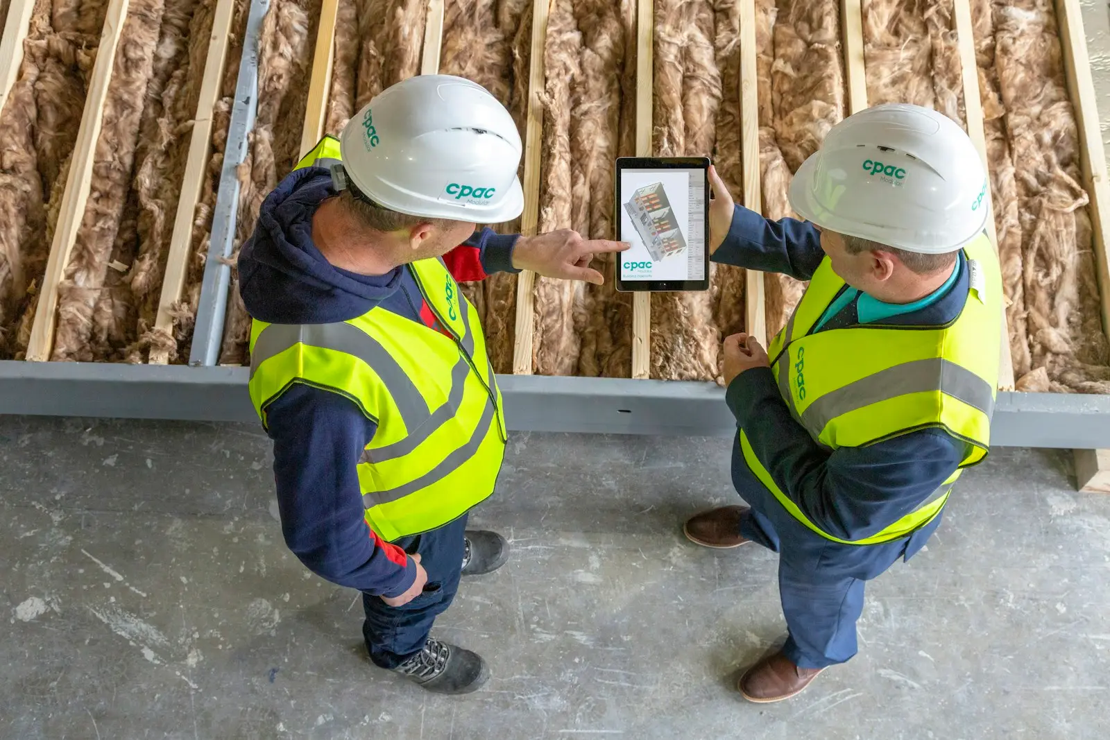 Twee bouwvakkers bekijken plannen op een tablet