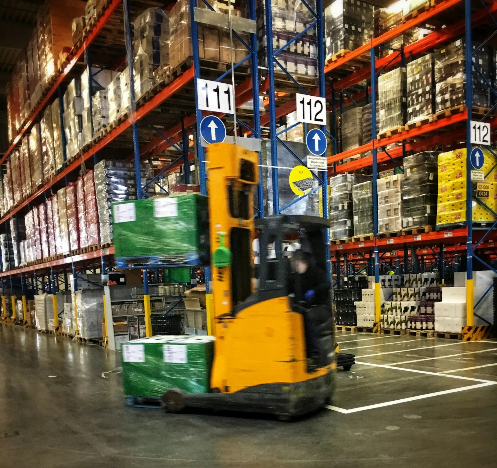 Heftruck in een magazijn met paletten