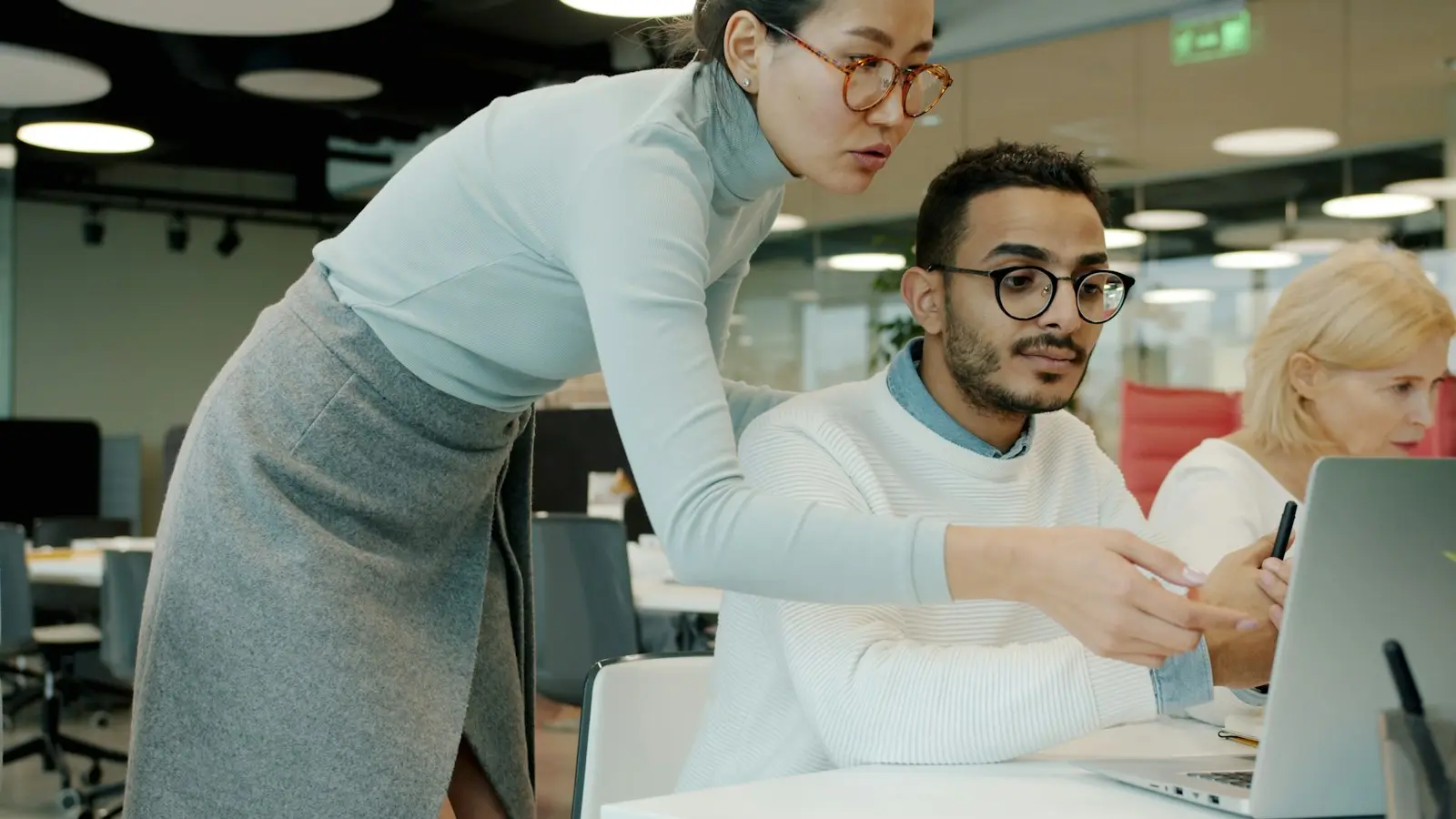 MINIMA-collega die een klant helpt aan de computer